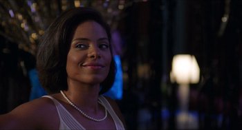 Movie still from “Love & Basketball” (2000), directed by Gina Prince-Bythewood – A woman wearing a white dress and a pearl necklace; Close Up shot, Over the shoulder angle