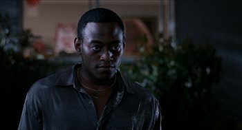 Movie still from “Love & Basketball” (2000), directed by Gina Prince-Bythewood – A man in a black shirt is looking at the camera; Close Up shot, Over the shoulder angle
