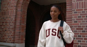 Movie still from “Love & Basketball” (2000), directed by Gina Prince-Bythewood – A young woman is standing in front of a brick wall; Close Up shot, Over the shoulder angle