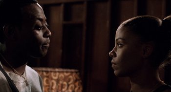 Movie still from “Love & Basketball” (2000), directed by Gina Prince-Bythewood – A man and a woman face to face in a dark room; Close Up shot, Over the shoulder angle