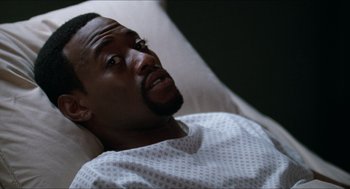 Movie still from “Love & Basketball” (2000), directed by Gina Prince-Bythewood – A man laying in a hospital bed looking up at the sky; Close Up shot, High angle