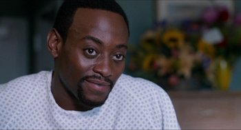 Movie still from “Love & Basketball” (2000), directed by Gina Prince-Bythewood – A person wearing a hospital gown; Close Up shot, High angle