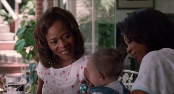 Movie still from “Love & Basketball” (2000), directed by Gina Prince-Bythewood – An older woman holding a baby in her arms; Close Up shot, Over the shoulder angle