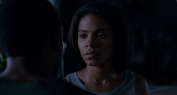 Movie still from “Love & Basketball” (2000), directed by Gina Prince-Bythewood – A woman is looking at the camera in the dark; Close Up shot, Over the shoulder angle
