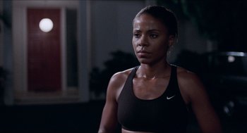 Movie still from “Love & Basketball” (2000), directed by Gina Prince-Bythewood – A woman in a sports bra is standing in a room; Close Up shot, Over the shoulder angle