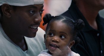 Movie still from “Love & Basketball” (2000), directed by Gina Prince-Bythewood – A man and a little girl smiling for the camera; Close Up shot, Over the shoulder angle