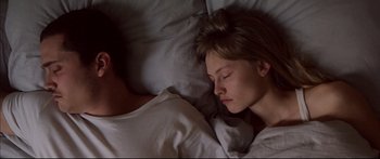 Movie still from “Love” (2015), directed by Gaspar Noé – A woman is sleeping in her bed with her eyes closed; Close Up shot, Overhead angle