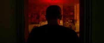 Movie still from “Love” (2015), directed by Gaspar Noé – A man standing in front of a red wall; Close Up shot, Low angle
