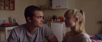 Movie still from “Love” (2015), directed by Gaspar Noé – A man and a woman sitting next to each other in a kitchen; Close Up shot, Over the shoulder angle