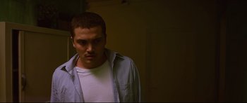 Movie still from “Love” (2015), directed by Gaspar Noé – A man in a white t - shirt and a blue shirt; Close Up shot, Low angle