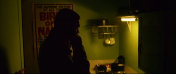 Movie still from “Love” (2015), directed by Gaspar Noé – A person standing in a room with a phone to his ear; Medium shot, Low angle