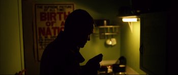 Movie still from “Love” (2015), directed by Gaspar Noé – A man is looking at his cell phone in the dark; Close Up shot, Low angle