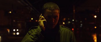 Movie still from “Love” (2015), directed by Gaspar Noé – A man is holding a cell phone up to his ear; Close Up shot, Low angle