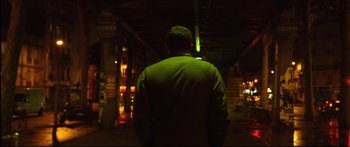 Movie still from “Love” (2015), directed by Gaspar Noé – A man standing in the dark in front of a building; Medium shot, Low angle