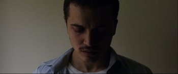 Movie still from “Love” (2015), directed by Gaspar Noé – A person wearing a white shirt; Close Up shot, High angle