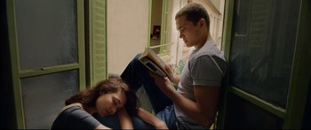 Movie still from “Love” (2015), directed by Gaspar Noé – A man and a woman are reading a book together; Medium shot, High angle