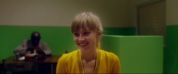 Movie still from “Love” (2015), directed by Gaspar Noé – A woman in a yellow shirt smiling for the camera; Close Up shot, Over the shoulder angle