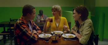 Movie still from “Love” (2015), directed by Gaspar Noé – A group of people sitting at a table with plates of food; Medium shot, Over the shoulder angle