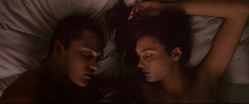 Movie still from “Love” (2015), directed by Gaspar Noé – A man and a woman laying in bed together; Close Up shot, Overhead angle