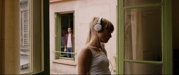 Movie still from “Love” (2015), directed by Gaspar Noé – A man and a woman are standing in front of a window; Medium shot, Over the shoulder angle