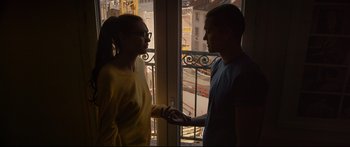 Movie still from “Love” (2015), directed by Gaspar Noé – A man and a woman standing next to each other near a window; Medium shot, Low angle
