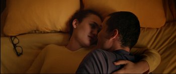 Movie still from “Love” (2015), directed by Gaspar Noé – A man and a woman laying in a bed kissing; Close Up shot, Overhead angle