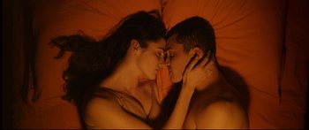 Movie still from “Love” (2015), directed by Gaspar Noé – A man and a woman laying in a bed together; Close Up shot, Overhead angle