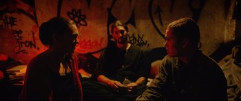 Movie still from “Love” (2015), directed by Gaspar Noé – A group of people sitting on a couch in a room; Medium shot, Over the shoulder angle