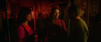 Movie still from “Love” (2015), directed by Gaspar Noé – A group of people standing in a dark room; Medium shot, Over the shoulder angle