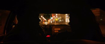 Movie still from “Love” (2015), directed by Gaspar Noé – A view from a car window at night of a city street lights; Extreme Close Up shot, Over the shoulder angle