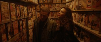Movie still from “Love” (2015), directed by Gaspar Noé – A man and a woman standing next to each other in a room; Medium shot, Over the shoulder angle
