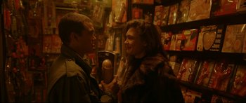 Movie still from “Love” (2015), directed by Gaspar Noé – A man and a woman are talking in a store; Close Up shot, Over the shoulder angle