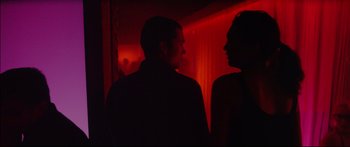 Movie still from “Love” (2015), directed by Gaspar Noé – A man and a woman standing next to each other in a room; Medium shot, Over the shoulder angle