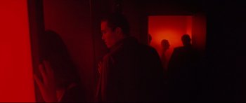 Movie still from “Love” (2015), directed by Gaspar Noé – A man standing next to a door in a room; Medium shot, Over the shoulder angle