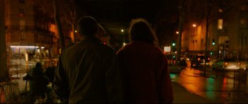 Movie still from “Love” (2015), directed by Gaspar Noé – A man and a woman walking down a street at night; Medium shot, High angle