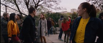 Movie still from “Love” (2015), directed by Gaspar Noé – A group of people standing around a park; Medium shot, Over the shoulder angle