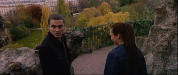 Movie still from “Love” (2015), directed by Gaspar Noé – A man and a woman standing next to each other on a sidewalk; Medium shot, Over the shoulder angle