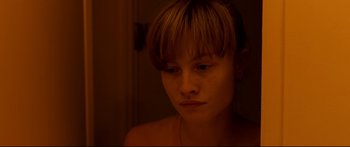 Movie still from “Love” (2015), directed by Gaspar Noé – A young woman with short blonde hair looking at the camera; Close Up shot, High angle