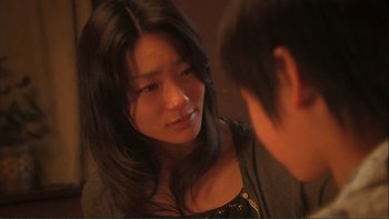 Movie still from “Love Exposure” (2008), directed by Sion Sono – A young woman looking into a mirror while talking to a young man; Close Up shot, Over the shoulder angle