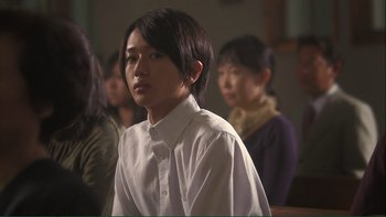 Movie still from “Love Exposure” (2008), directed by Sion Sono – A group of people sitting in front of a wall; Close Up shot, Over the shoulder angle