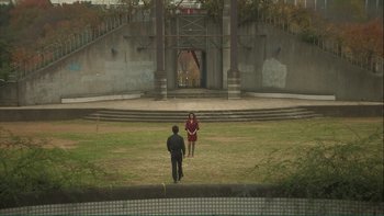 Movie still from “Love Exposure” (2008), directed by Sion Sono – A man and a woman are standing in an open field; Extreme Wide shot, High angle