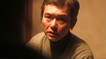 Movie still from “Love Exposure” (2008), directed by Sion Sono – A person wearing a sweater; Close Up shot, Low angle