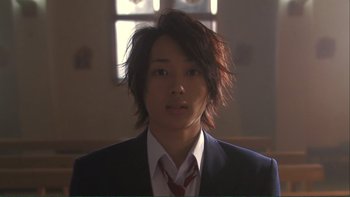 Movie still from “Love Exposure” (2008), directed by Sion Sono – A young man in a suit and a tie; Close Up shot, Low angle