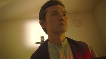Movie still from “Love Exposure” (2008), directed by Sion Sono – A person wearing a suit and tie; Close Up shot, Low angle