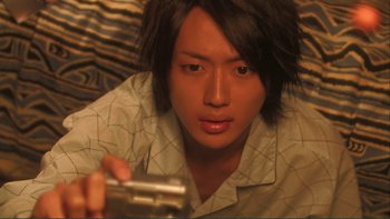 Movie still from “Love Exposure” (2008), directed by Sion Sono – A young man holding a video game remote control; Extreme Close Up shot, High angle