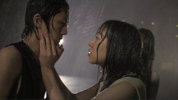 Movie still from “Love Exposure” (2008), directed by Sion Sono – Two people in the rain touching each other's hair; Extreme Close Up shot, Low angle