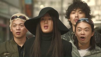 Movie still from “Love Exposure” (2008), directed by Sion Sono – A group of people standing next to each other wearing hats; Close Up shot, Low angle