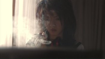 Movie still from “Love Exposure” (2008), directed by Sion Sono – A woman with a microphone in her hand; Close Up shot, Low angle