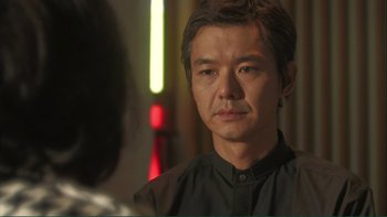 Movie still from “Love Exposure” (2008), directed by Sion Sono – A person wearing a black shirt; Close Up shot, Over the shoulder angle