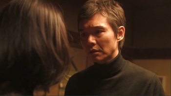 Movie still from “Love Exposure” (2008), directed by Sion Sono – A man in a black shirt is looking at a woman; Close Up shot, Over the shoulder angle